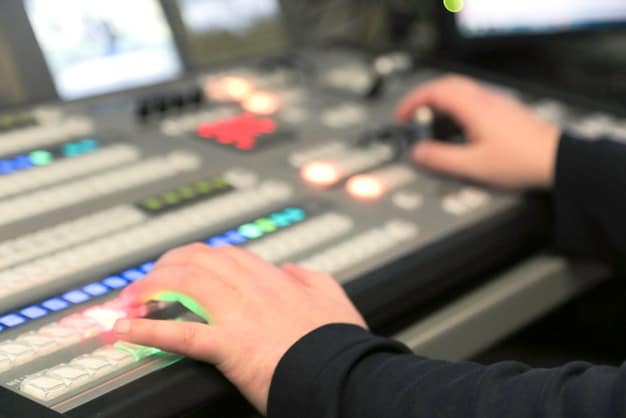 A close-up shot of a sound engineer adjusting the settings on a mixing board at a live rock concert. The board is complex with many knobs and faders, and the engineer is focused with headphones on. The background shows a blurred stage with musicians performing.