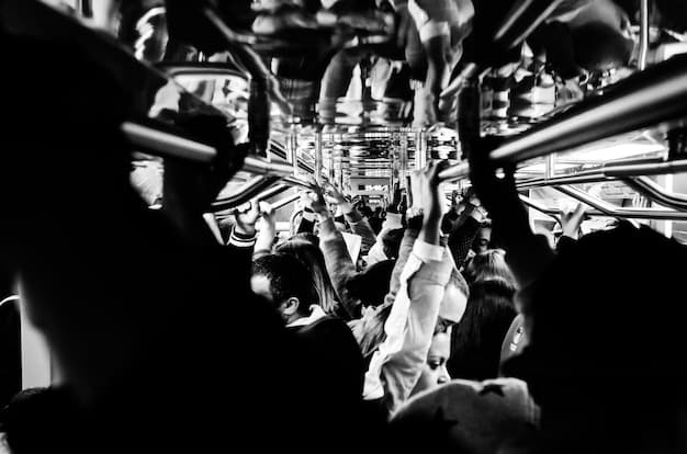 A black and white photo of a crowded concert venue. The focus is on the stage, where a rock band is performing silhouetted against bright stage lights. The crowd is a sea of faces and raised hands, creating a sense of excitement and energy.