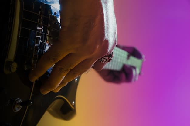 A close-up shot of a band member tuning a guitar backstage before a concert. The image is slightly out of focus, conveying a sense of anticipation and nervousness. Soft, diffused lighting.