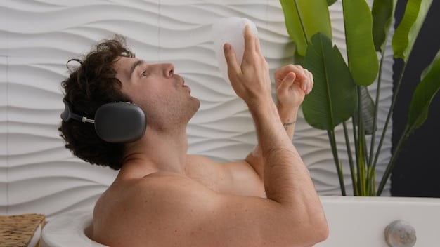 A person carefully cleaning their high-fidelity earplugs under running water, with a soft cloth nearby. The focus is on hygiene and maintenance.