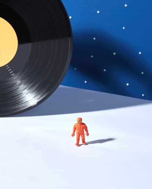 A split image: on one side, a traditional vinyl record; on the other, a digital NFT token. The image visually represents the contrast between traditional and digital forms of music ownership.